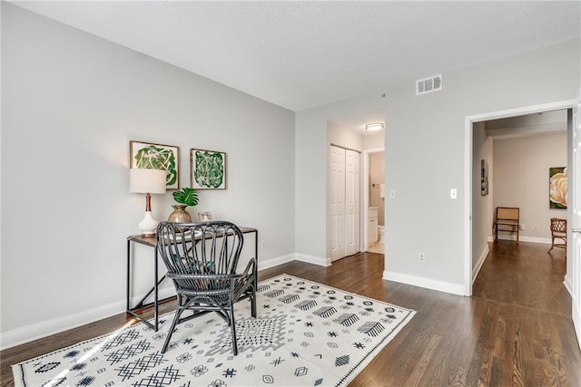 office area featuring visible vents, baseboards, and dark wood-style flooring