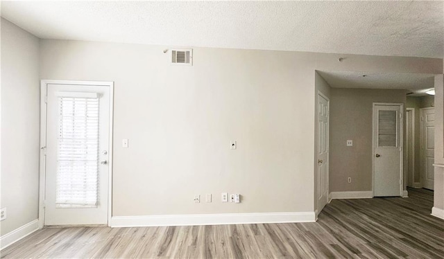 1074 Peachtree Walk NE Unit B 216, Atlanta, GA 30309 - spare room featuring visible vents, a textured ceiling, baseboards, and wood finished floors