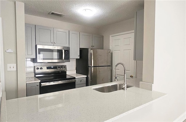 1074 Peachtree Walk NE Unit B 216, Atlanta, GA 30309 - kitchen featuring visible vents, gray cabinets, a sink, stainless steel appliances, and decorative backsplash