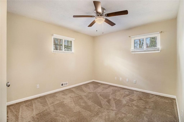 empty room with ceiling fan, carpet flooring, and a wealth of natural light