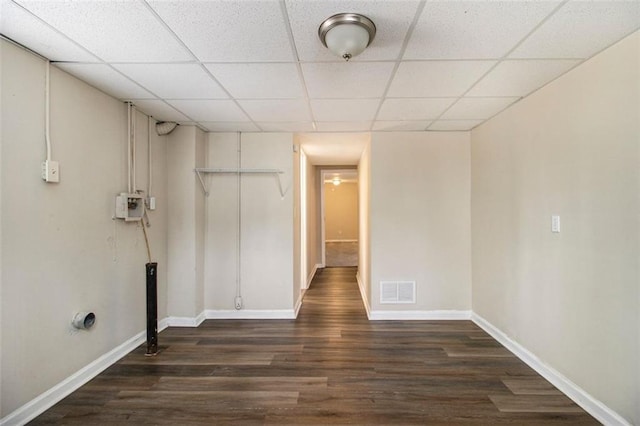 interior space featuring a drop ceiling and dark hardwood / wood-style flooring