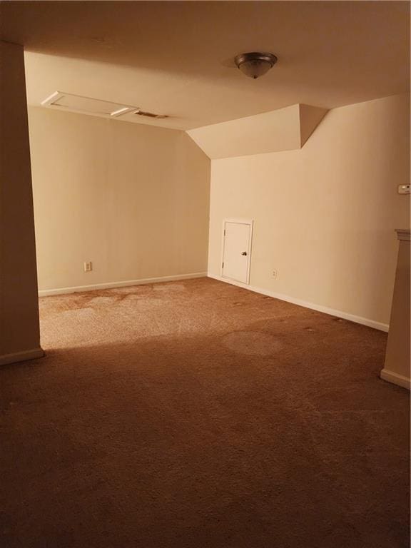 carpeted empty room featuring vaulted ceiling