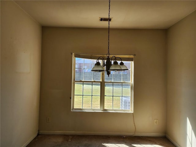 unfurnished room with a chandelier