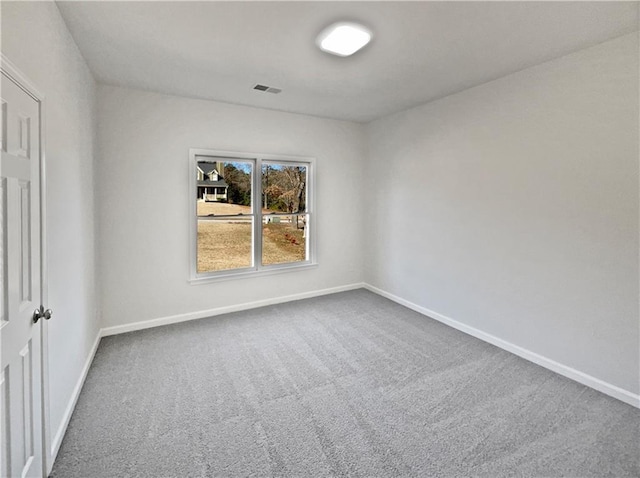 empty room featuring carpet flooring, visible vents, and baseboards