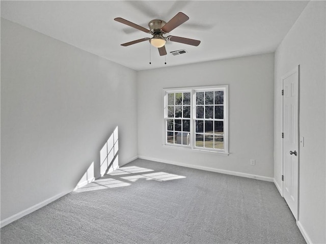 carpeted empty room featuring ceiling fan, visible vents, and baseboards