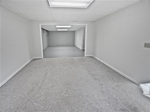 interior space with carpet floors, a paneled ceiling, and baseboards