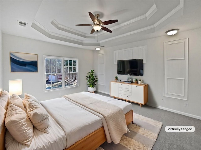 bedroom with a tray ceiling, visible vents, crown molding, and baseboards