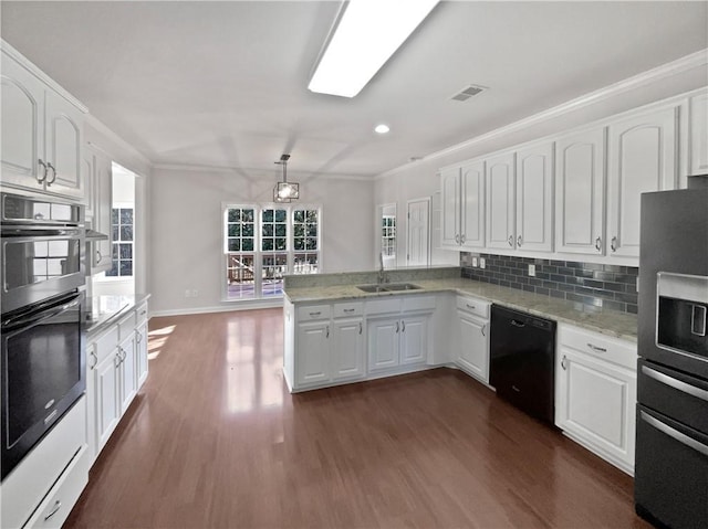 kitchen with a peninsula, black dishwasher, white cabinets, and a sink