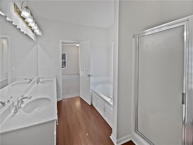 bathroom featuring a bath, a sink, and wood finished floors