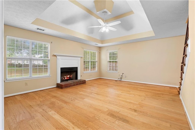 2881 Bridle Creek Dr SW, Conyers, GA 30094 - unfurnished living room featuring a raised ceiling, light wood-style floors, baseboards, and ceiling fan