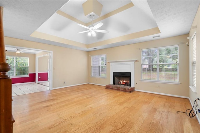 2881 Bridle Creek Dr SW, Conyers, GA 30094 - unfurnished living room featuring ceiling fan, a raised ceiling, wood finished floors, and a textured ceiling