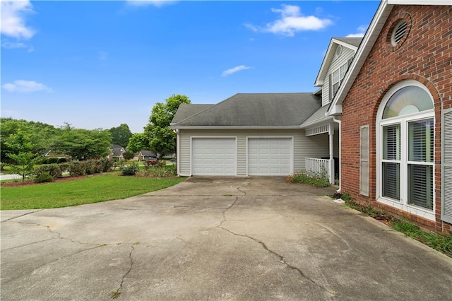 2881 Bridle Creek Dr SW, Conyers, GA 30094 - view of side of property featuring brick siding, driveway, an attached garage, a yard, and roof with shingles