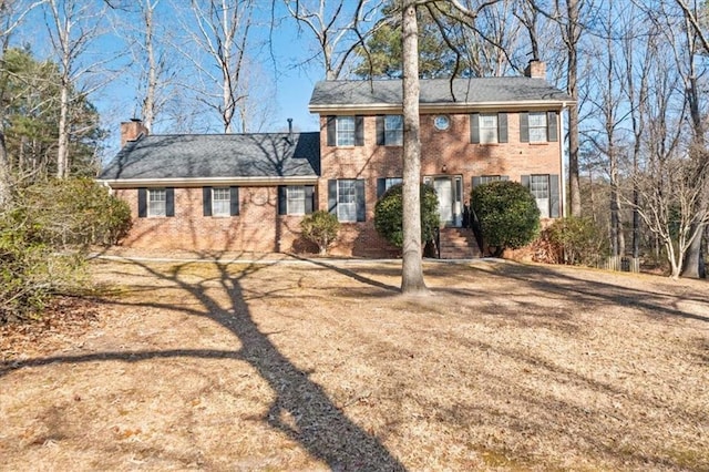 colonial inspired home with a front lawn