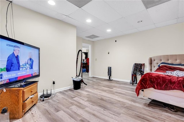 bedroom featuring light wood finished floors, recessed lighting, a paneled ceiling, and baseboards