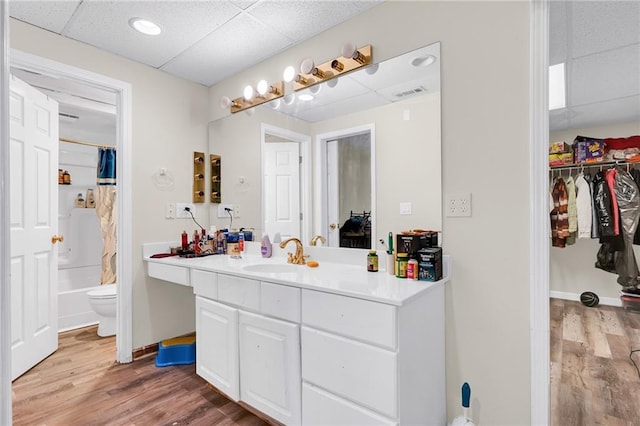 full bathroom with toilet, vanity, a paneled ceiling, and wood finished floors