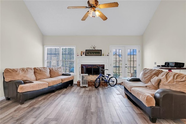 living room with ceiling fan, a healthy amount of sunlight, wood finished floors, and a fireplace