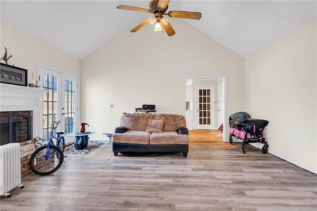 living room with light wood-style flooring, radiator, a ceiling fan, and french doors