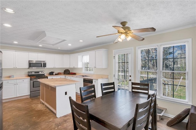 kitchen featuring a kitchen island, recessed lighting, stainless steel appliances, white cabinets, and a textured ceiling