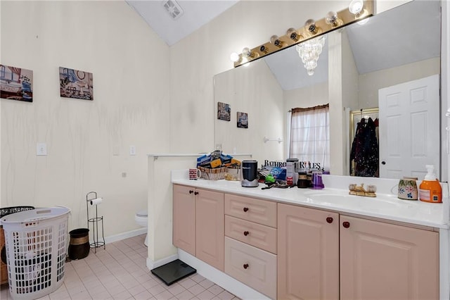 bathroom featuring visible vents, toilet, tile patterned flooring, lofted ceiling, and vanity