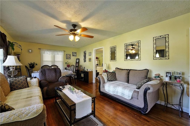 living room with ceiling fan, dark hardwood / wood-style floors, and a textured ceiling