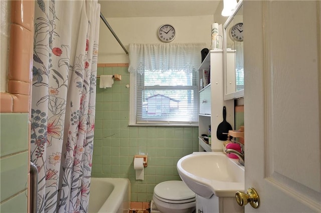 full bathroom with vanity, tile walls, shower / bath combo with shower curtain, and toilet