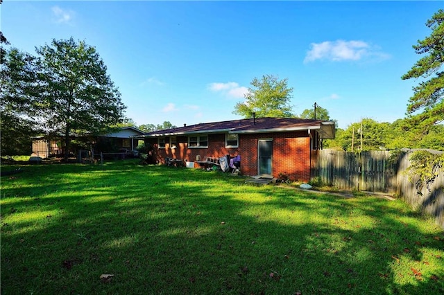 rear view of house featuring a yard