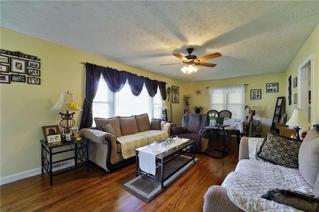 living room featuring ceiling fan, a textured ceiling, and dark hardwood / wood-style flooring