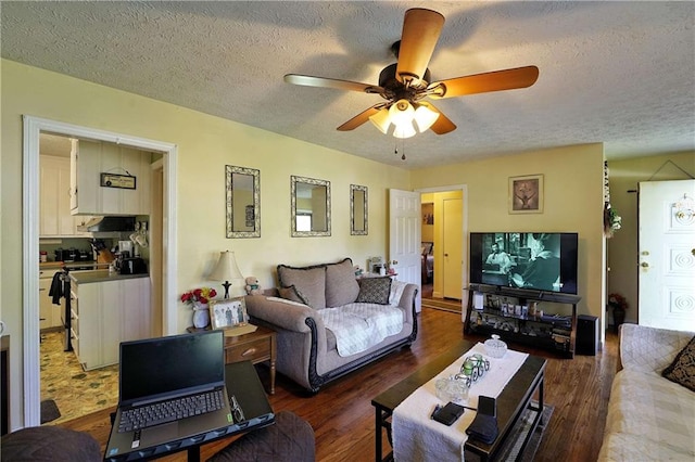 living room with ceiling fan, dark wood-type flooring, and a textured ceiling