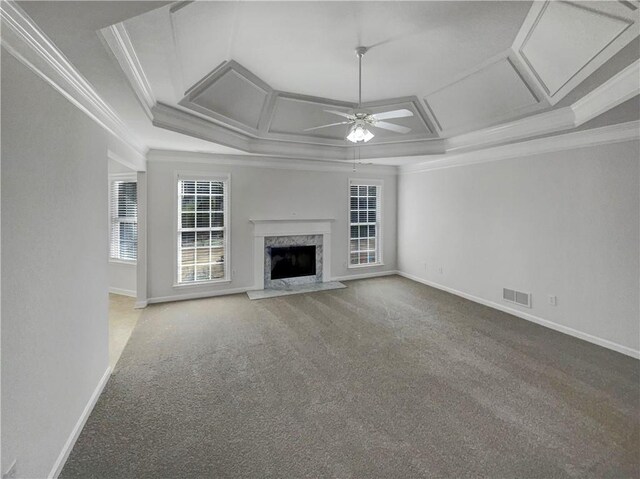 unfurnished living room with coffered ceiling, ceiling fan, carpet, a high end fireplace, and crown molding