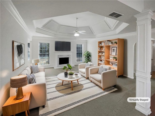 carpeted living room with ceiling fan, decorative columns, a high end fireplace, and ornamental molding