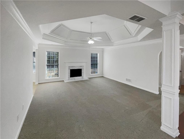 unfurnished living room featuring decorative columns, ceiling fan, dark colored carpet, a high end fireplace, and crown molding