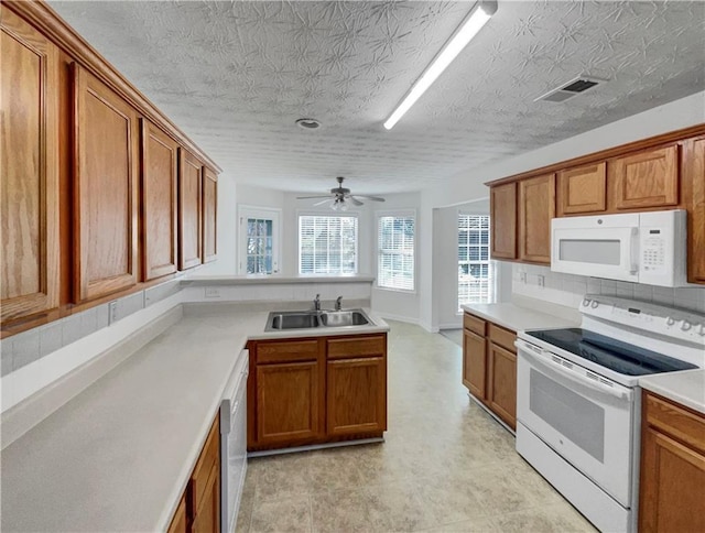 kitchen featuring ceiling fan, decorative backsplash, sink, and white appliances