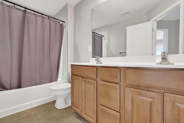 bathroom featuring toilet, vanity, shower / bath combo with shower curtain, and tile patterned floors
