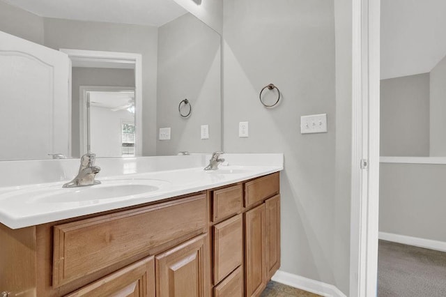 full bath with double vanity, ceiling fan, and baseboards