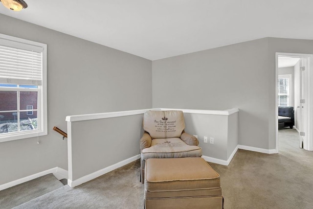living area featuring an upstairs landing, carpet floors, and baseboards