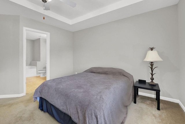bedroom featuring carpet flooring, baseboards, and a tray ceiling