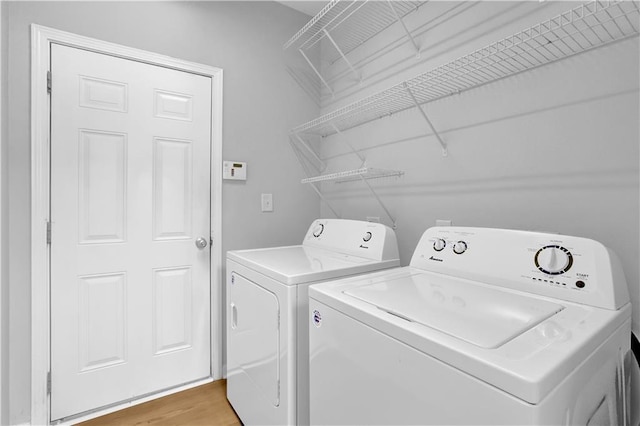 washroom featuring washer and dryer and light wood finished floors