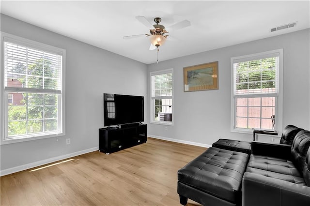 sitting room featuring light wood-style flooring, baseboards, and a ceiling fan