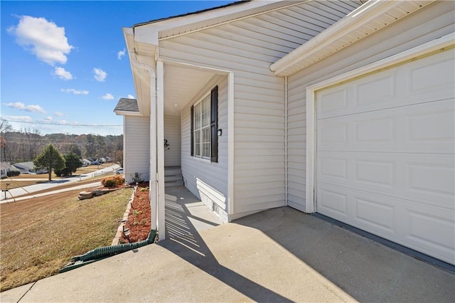 property entrance featuring concrete driveway and a garage