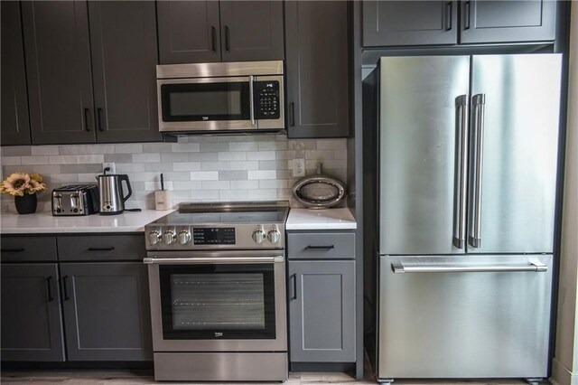 kitchen with appliances with stainless steel finishes and backsplash