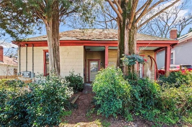 view of front of home featuring covered porch and a shingled roof