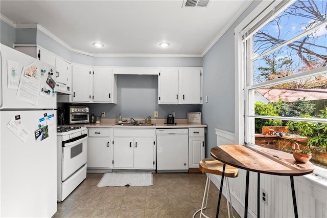 kitchen featuring under cabinet range hood, ornamental molding, white appliances, and a sink