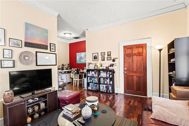 living area featuring visible vents, baseboards, wood finished floors, and crown molding