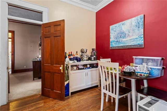 dining room featuring crown molding, baseboards, and wood finished floors