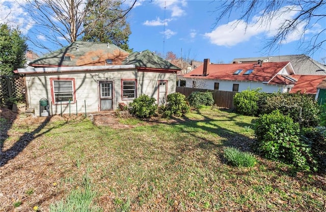 rear view of house with a yard and fence