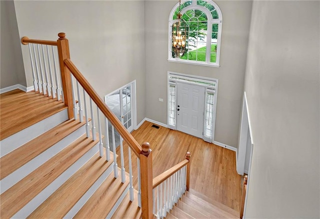 4910 Aldbury Ln, Suwanee, GA 30024 - foyer entrance with wood finished floors, a towering ceiling, baseboards, and a chandelier
