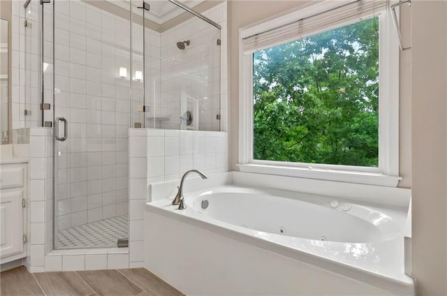 4910 Aldbury Ln, Suwanee, GA 30024 - bathroom with a tub with jets, a stall shower, and wood finished floors