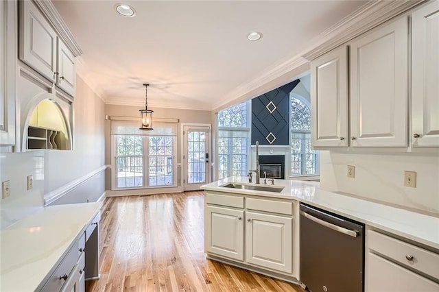 kitchen featuring dishwasher, sink, hanging light fixtures, light hardwood / wood-style floors, and crown molding