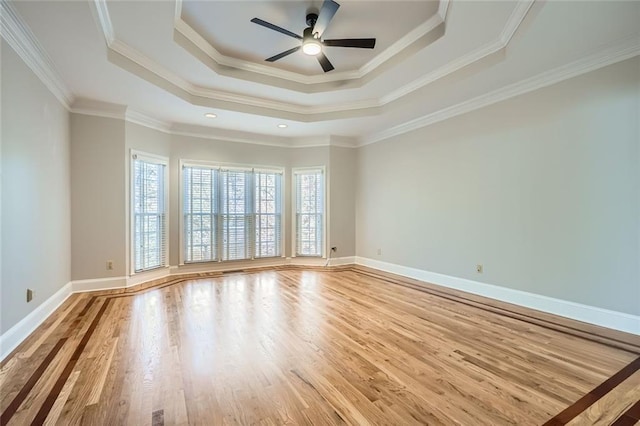 unfurnished room with crown molding, ceiling fan, a raised ceiling, and hardwood / wood-style floors