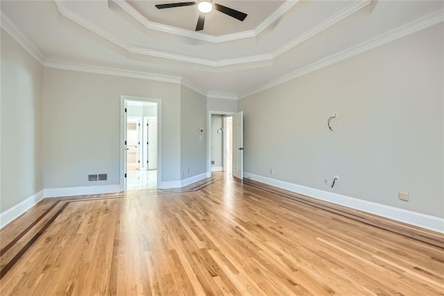 unfurnished room with a tray ceiling, ornamental molding, light hardwood / wood-style floors, and ceiling fan